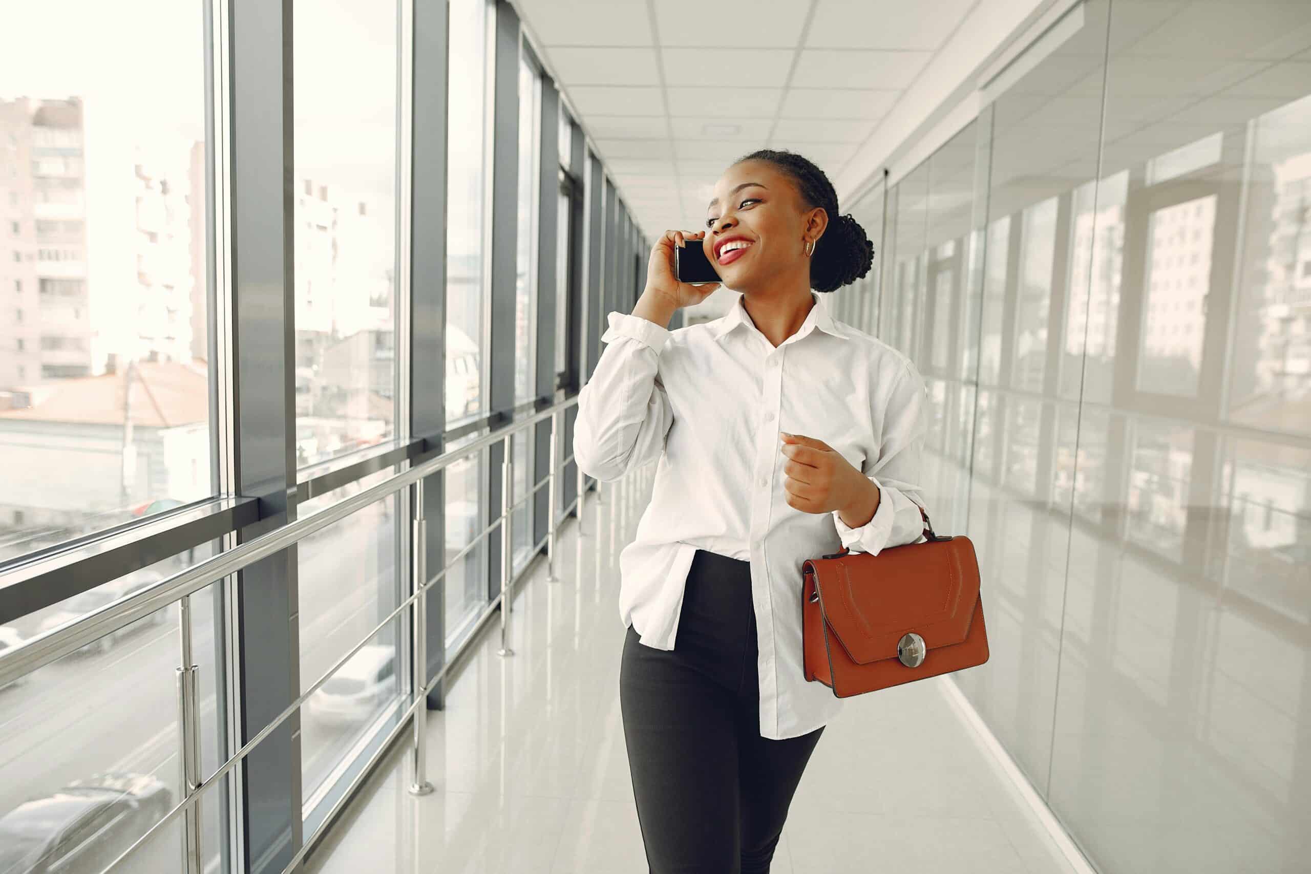 Black woman walking in hallway talking on cellphone